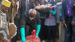 Presiden Sierra Leone Ernest Bai Koroma dan Presiden Liberia Ellen Johnson Sirleaf meletakan bunga saat menghadiri pemakaman korban longsor di pemakaman Paloko, Sierra Leone,(17/8). Sekitar 300 orang tewas akibat musibah tersebut. (AFP Photo/Seyllou)