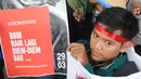 Seorang mahasiswa yang tergabung dalam Kesatuan Aksi Mahasiswa Muslim Indonesia (KAMMI) Bogor menunjukkan poster saat melakukan aksi menolak harga kenaikan BBM di Jalan Ir. H.Djuanda, Bogor (29/03). (Merdeka.com/Arie Basuki)