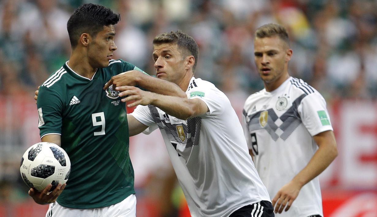 Gelandang Jerman, Thomas Mueller, berusaha merebut bola dari striker Meksiko, Raul Jimenez, pada laga Grup F Piala Dunia di Stadion Luzhniki, Moskow, Minggu (17/6/2018). Meksiko menang 1-0 atas Jerman. (AP/Victor Caivano)