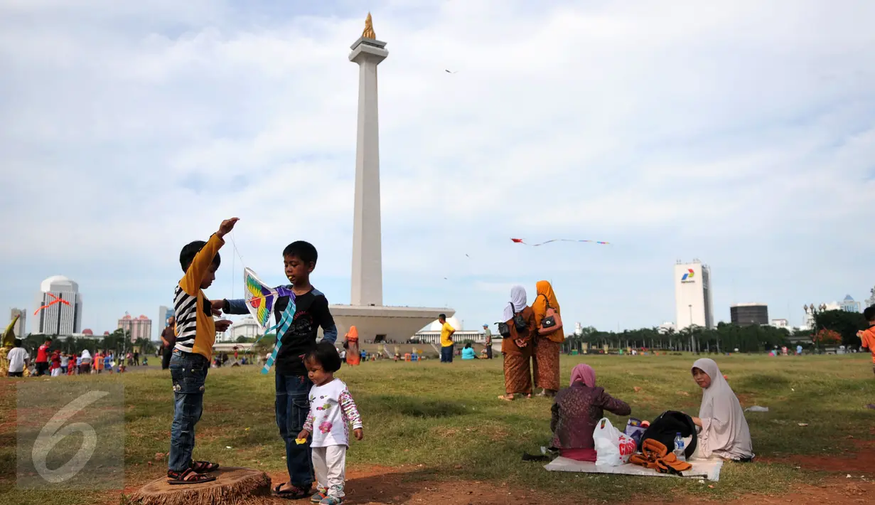 Sejumlah pengunjung bermain layang-layang di kawasan Monas, Jakarta, Sabtu (26/12/2015). Libur Natal dimanfaatkan sejumlah warga untuk berwisata ke tempat yang menjadi ikon Jakarta tersebut. (Liputan6.com/Yoppy Renato)