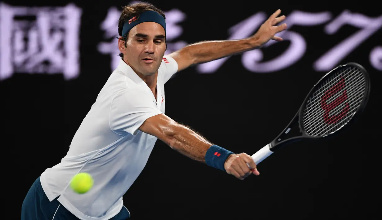 Petenis Swiss, Roger Federer melakukan servis ke arah lawannya Taylor Fritz dari AS dalam babak 32 besar Australia Terbuka di Melbourne, Jumat (18/1). Federer melaju mulus ke babak 16 besar setelah menang tiga set langsung 6-2 7-5 6-2. (WILLIAM WEST/AFP)