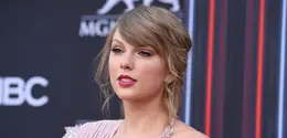 Penyanyi Taylor Swift berpose saat tiba menghadiri Billboard Music Awards di MGM Grand Garden Arena di Las Vegas (20/5).Taylor Swift tampil cantik dengan gaun Versace warna merah muda dengan belahan paha tinggi. (AP Photo/Jordan Strauss)