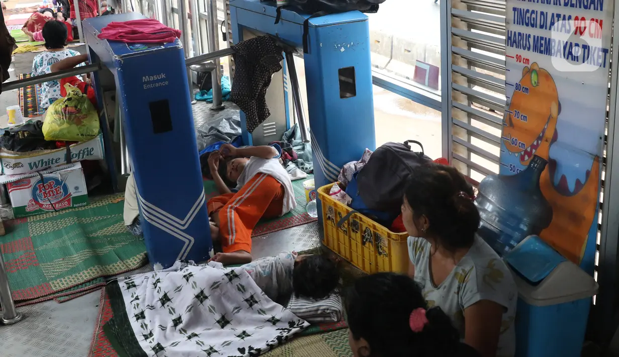 Warga korban banjir mengungsi di Halte Transjakarta Jembatan Baru, Cengkareng, Jakarta, Jumat (3/1/2020). Warga sekitar terpaksa mengungsi ke Halte Transjakarta Jembatan Baru karena rumah mereka masih terendam banjir. (Liputan6.com/Angga Yuniar)