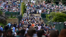 Antrian panjang penonton saat memasuki lapangan Tenis Wimbledon Championships 2016 di The All England Lawn Tennis Club, Wimbledon,  London, (27/6/2016). (AFP/Glyn Kirk)