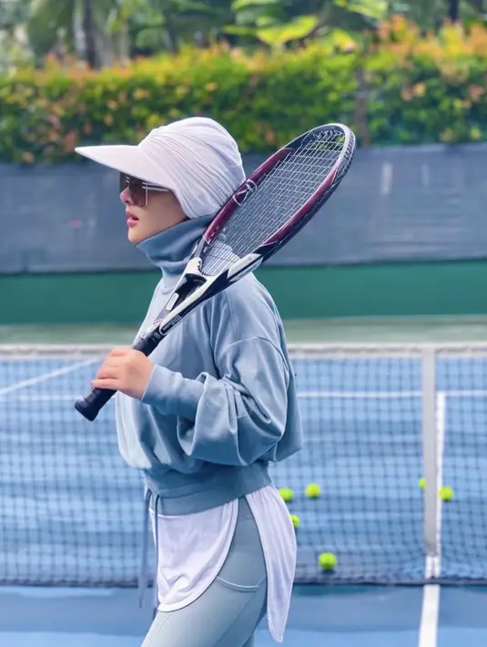 Sedang menekuni olahraga Tenis, Syahrini tampil dengan crop top jaket halterneck dan kaos putih yang menutupi bagian bawahnya. Ia mengenakan kerudung lengkap dengan topinya berwarna putih. (@princessyahrini)