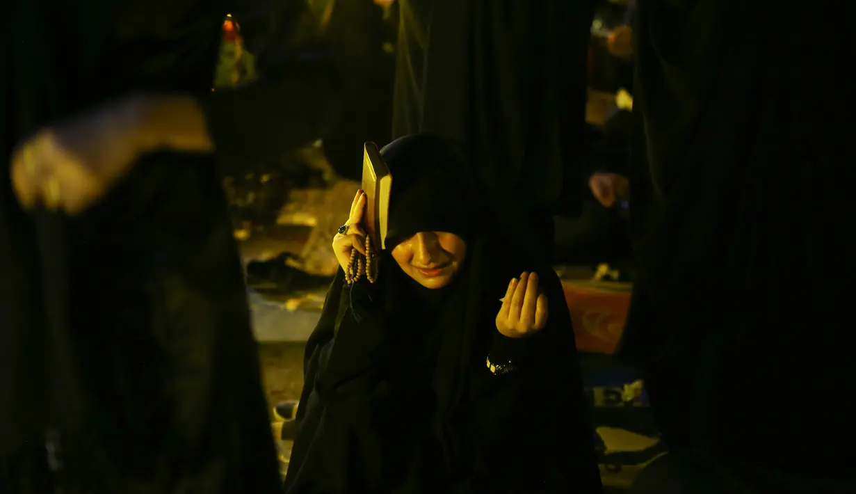 Ekspresi seorang wanita saat berdoa pada malam Ramadan di Teheran, Iran (16/6). Mereka percaya bahwa malam Lailatul Qadar jatuh pada tanggal 19, 21 atau 23 Ramadan. (AP Photo/Vahid Salemi)