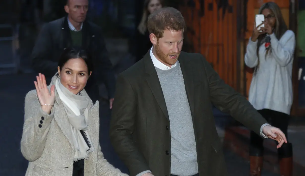 Meghan Markle melambaikan tangan saat kunjungan Pangeran Harry ke stasiun radio Reprezent 107,3 FM di Brixton, London, Selasa, (9/1). Kunjungan ini untuk melihat pekerjaan stasiun radio yang mendukung kreatifitas pemuda. (AP Photo/Dominic Lipinski, Pool)