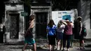 Turis melihat peta pemakaman Pere Lachaise sebelum memulai kunjungan mereka di Paris (22/7/2019). Pemakaman Père adalah salah satu pemakaman terbesar di Paris (luasnya sekitar 44 hektar 110 acre). (AFP Photo/Philippe Lopez)