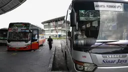 Seorang pria berjalan di antara bus Antar Kota Antar Provinsi (AKAP) di Terminal Pulo Gebang, Jakarta, Kamis (8/6). Pemprov DKI Jakarta menyiapkan terminal Pulo Gebang sebagai pusat pemberangkatan mudik Lebaran 2017. (Liputan6.com/Faizal Fanani)