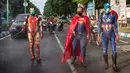 Petugas kepolisian yang berpakaian superhero menyemprotkan cairan disinfektan di jalan kawasan Pasuruan, Jawa Timur, Kamis (9/4/2020). Penyemprotan cairan disinfektan tersebut bertujuan untuk mengantisipasi penyebaran Virus Corona (COVID-19). (JUNI KRISWANTO / AFP)