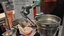 Robot koki bernama Sophie meracik semangkuk laksa saat demonstrasi memasak di Singapura pada 26 Juli 2019. Sebanyak 80 mangkuk laksa dapat disajikan robot koki tersebut dalam waktu satu jam. (Roslan RAHMAN / AFP)