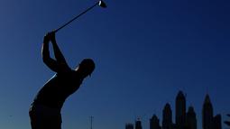 Siluet pegolf Inggris, Danny Willett, saat memukul bola dalam turnamen golf Dubai Desert Classic 2016 di Emirates Golf Club, Dubai, (7/2/2016). (AFP/Karim Sahib)