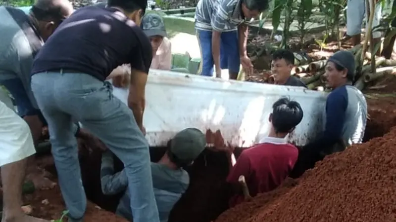 Peti Jenazah Di Angkat Dari Dalam Makam. (Sabtu, 26/06/2021). (Dokumentasi Polres Serang Kota).