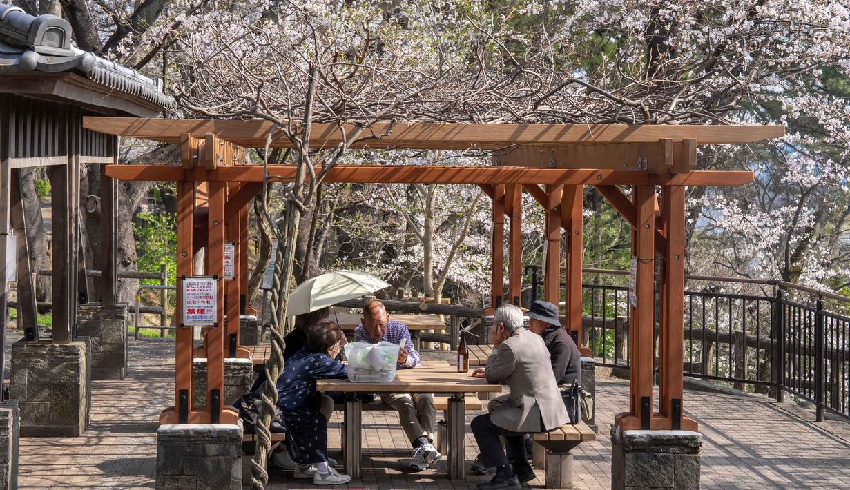 Di momen ini orang-orang dari segala usia akan berkumpul di bawah pohon sakura untuk hanami. Tampak dalam foto, orang-orang berbincang di bawah pohon sakura di sebuah taman di Tokyo pada Senin 30 Maret 2026. (Yuichi YAMAZAKI/AFP)