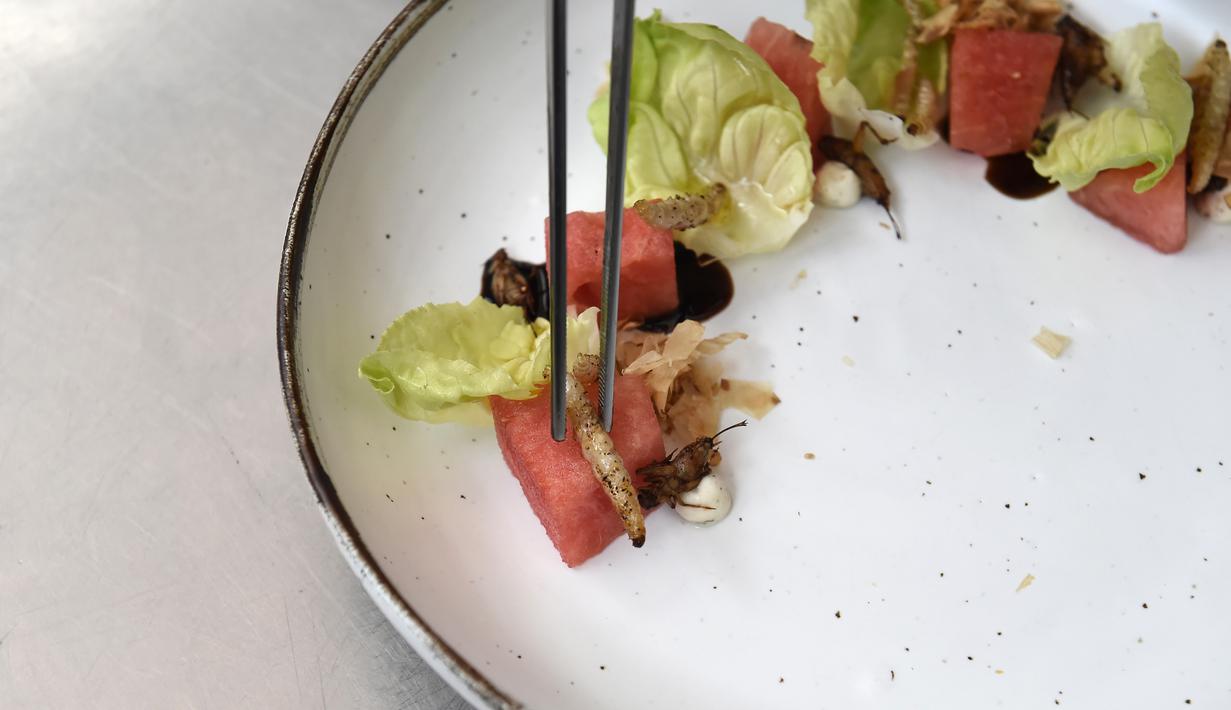 <p>Ulat bambu yang dogoreng dihidangkan di atas salad semangka di restoran Insects in the Backyard, Bangkok, 20 Agustus 2017. Restoran kelas atas ini menjadi yang pertama membuka menu hidangan makanan dengan kombinasi serangga. (LILLIAN SUWANRUMPHA/AFP)</p>