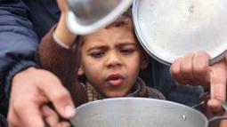 Puluhan ribu anak-anak menjadi korban perang yang sedang berlangsung antara Israel dan Hamas di wilayah Gaza. Tampak dalam foto, seorang anak laki-laki Palestina berusaha mendapatkan makanan dari lokasi distribusi di Kota Gaza pada 19 November 2024. (Omar AL-QATTAA/AFP)