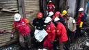 Petugas penyelamat membawa jenazah korban setelah kebakaran di gedung apartemen di Dhaka (21/2). Setidaknya 69 orang tewas dalam kebakaran besar yang melanda gedung  yang juga digunakan sebagai gudang bahan kimia. (AFP Photo/Munir Uz Zaman)