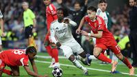 Di babak kedua, Benfica tampil lebih agresif demi mengejar ketertinggalan agregat dan melupakan sektor petahanan. Tampak dalam foto, gelandang SL Benfica asal Luksemburg, Leandro Barreiro (kiri) berebut bola dengan gelandang Real Madrid, Eduardo Camavinga (tengah) selama pertandingan leg kedua babak playoff 16 besar Liga Champions 2025/2026 di Stadion Santiago Bernabeu pada Rabu 25 Februari 2026 waktu setempat atau Kamis (26/2/2026) dini hari WIB. (Thomas COEX/AFP)
