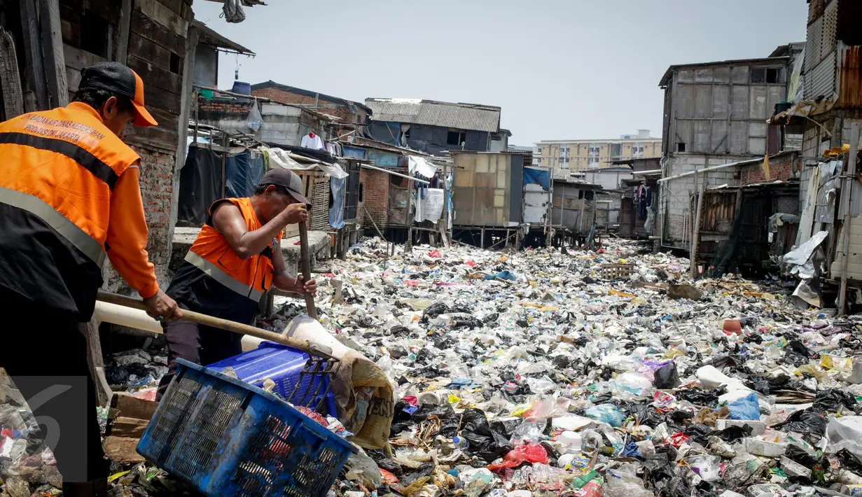 Petugas mengangkut sampah yang menumpuk di Kali Gendong, Penjaringan, Jakarta Utara, Kamis (16/3). Ceceran sampah plastik limbah rumah tangga terlihat menyerupai daratan menumpuk di sepanjang Kali Gendong. (Liputan6.com/Faizal Fanani)