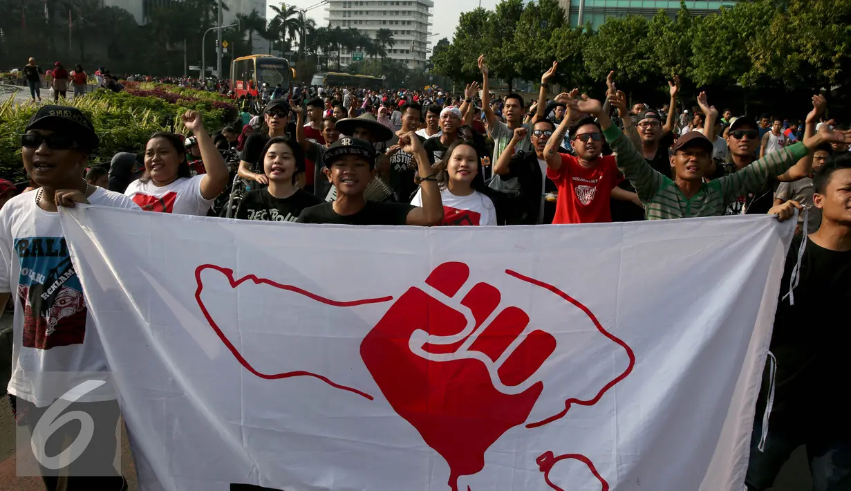 Masyarakat aliansi Forum Rakyat Bali di Jakarta melakukan aksi saat Car Free Day (CFD) di Bundaran Hotel Indonesia, Jakarta, Minggu (4/9). Dalam aksinya mereka bernyanyi menyerukan Tolak Reklamasi Teluk Benoa. (Liputan6.com/Johan Tallo)