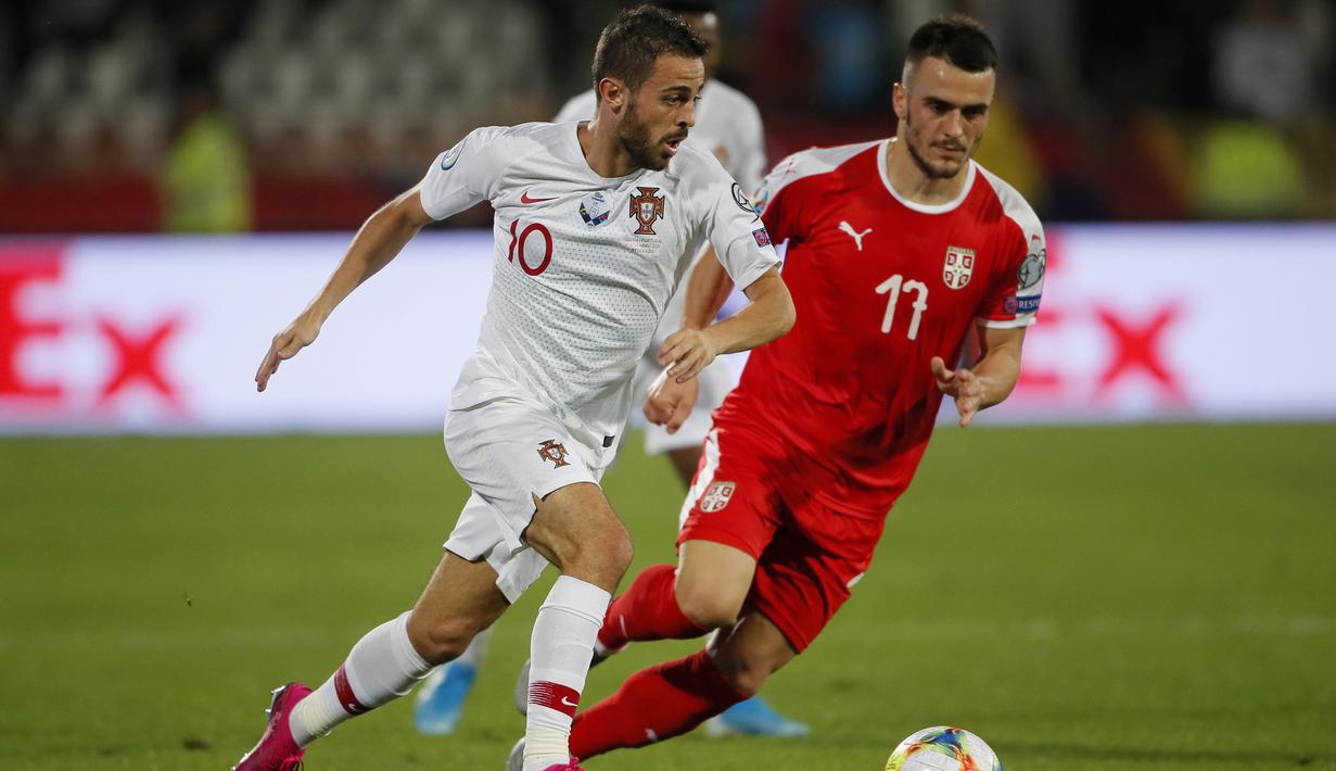 Gelandang Portugal, Bernardo Silva, berebut bola dengan gelandang Serbia, Filip Kostic, pada laga Kualifikasi Piala Eropa 2020 di Belgrade, Sabtu (7/9). Serbia kalah 2-4 dari Portugal. (AFP/Pedja Milosavljevic)
