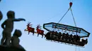 Para tamu menikmati makan malam di "Santa in the sky", yang diangkat dengan crane dan dihias menyerupai "Santa Sleigh" di Brussels, Belgia, 25 November 2016. Tempat ini didekorasi seperti kereta Santa Claus menjelang perayaan Natal. (REUTERS/Yves Herman)
