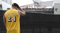 Gennesys Cabral, dari Los Angeles, mengenakan jersey Kobe Bryant di luar Staples Center, Los Angeles (26/1/2020). Selain Bryant, empat orang lainnya dalam helikopter itu juga dinyatakan meninggal dunia. (AP Photo/Chris Pizzello)