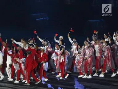 Parade atlet Indonesia saat upacara Penutupan Asian Games 2018 di Stadion Utama Gelora Bung Karno, Jakarta, Minggu (2/9). Mereka mengenakan jas hujan yang mengguyur Jakarta. (Liputan6.com/Helmi Fithriansyah)