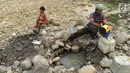 Warga mengambil air pada lubang di aliran Sungai Cipamingkis yang kering, Cibarusah, Bekasi, Jabar, Kamis (2/8). Dua bulan tak diguyur hujan menyebabkan warga perbatasan Bogor-Bekasi dilanda kekeringan dan kesulitan air bersih. (Merdeka.com/Arie Basuki)