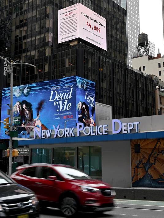 Papan berupa jam kematian yang disebut "Trump Death Clock" di Times Square, New York City pada 8 Mei 2020. Papan hasil ide dari pembuat film, Eugene Jarecki ini menampilkan jumlah kematian yang disebabkan Presiden AS Donald Trump menunda respons terhadap pandemi COVID-19. (TIMOTHY A. CLARY/AFP)
