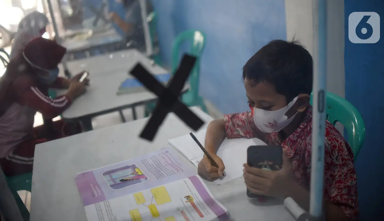 Sejumlah siswa mengikuti PJJ di Balai Warga RT 05/RW 02 Kelurahan Galur, Johar Baru, Jakarta, Selasa (15/8/2020). Fasilitas internet gratis yang digalakan Pemprov) DKI Jakarta ditujukan untuk mengatasi persoalan kesenjangan digital selama pandemi Covid-19. (Liputan6.com/Fery Pradolo)