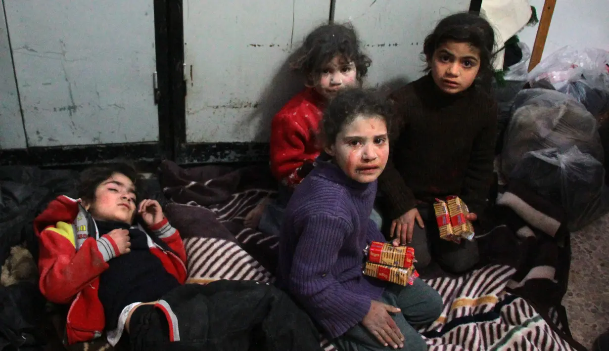 Anak-anak menangis di sebuah rumah sakit setelah pasukan pemerintah membombardir wilayah Ghouta Timur, Damaskus, Suriah, Senin (19/2). Warga khawatir operasi pasukan Suriah itu akan mengubah tempat mereka menjadi Aleppo. (AFP PHOTO/Hamza Al-Ajweh)