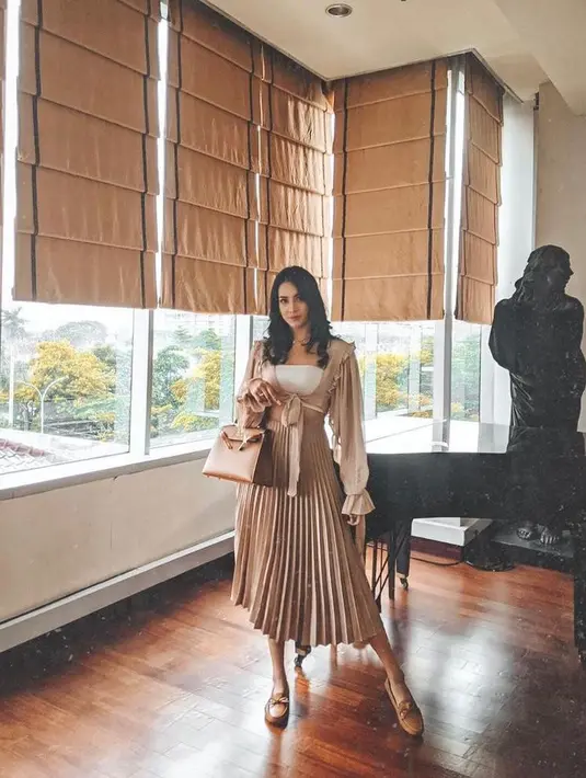 Tampil kece dengan padu padan wrap cardigan warna nude dan rok plisket warna cokelat muda ala Anya Geraldine satu ini. (Instagram/anyageraldine).