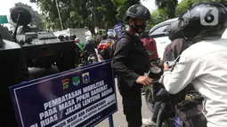 Petugas dari Korps Brimob memeriksa surat keterangan warga saat penyekatan di Jalan Lenteng Agung Raya, Jakarta, Selasa (6/7/2021). Petugas hanya mengizinkan warga yang memiliki kepentingan esensial atau mendesak bisa melintas jalan Lenteng Agung Raya. (Liputan6.com/Helmi Fithriansyah)