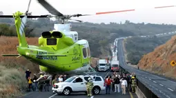 Helikopter yang membawa korban kecelakaan antara sebuah van dan truk kargo  meninggalkan lokasi di jalan raya Negara Bagian Jalisco, Meksiko, Rabu (18/12/2019). Jlaan raya sebagian besar ditutup untuk lalu lintas saat petugas forensik mengevakuasi jenazah dari bangkai kendaraan. (Ulises Ruiz / AFP)