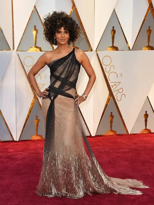 Aktris Halle Berry ikut meramaikan karpet merah ajang Oscar 2017 di Dolby Theatre, Los Angeles, Minggu (26/2). Berambut kribo, pemeran 'Catwoman' itu terlihat anggun mengenakan gaun panjang berwarna perak. (Photo by Jordan Strauss/Invision/AP)