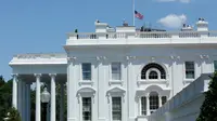 Pemandangan bendera setengah tiang di Gedung Putih, Washington DC, sebagai tanda berduka atas penembakan brutal klub gay Pulse di Kota Orlando, Florida, Amerika Serikat (AS), Minggu (12/6). (AFP PHOTO/Yuri GRIPAS)