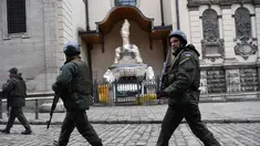 Prajurit Ukraina berjalan melewati patung-patung yang dibungkus di Katedral Latin di Lviv, 5 Maret 2022. Di tengah meningkatnya konflik antara Rusia dan Ukraina, warga kota Lviv membungkus semua patung di kota itu untuk melindungi warisan sejarahnya dari kemungkinan serangan. (Daniel LEAL/AFP)