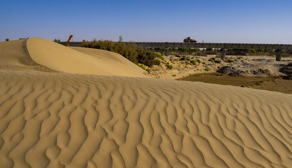 Para pekerja bekerja di lokasi konstruksi sebuah jembatan jaringan kereta Hotan-Ruoqiang di Daerah Otonom Uighur Xinjiang, China, 25 September 2020. Dengan total panjang sekitar 825 kilometer, jaringan kereta itu merupakan bagian penting dari loop kereta di Lembah Tarim. (Xinhua/Hu Huhu)