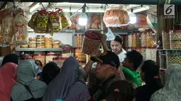 Calon pembeli mengantre untuk membeli kue kering di toko kue Pasar Jatinegara, Jakarta, Selasa (14/6). Harga kue kering yang dijual di tempat tersebut berkisar antara Rp 25 ribu - Rp 160 ribu per kg. (Liputan6.com/Gempur M Surya)