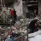 Warga Palestina mencari puing-puing bangunan untuk mencari barang-barang yang masih bisa diselamatkan setelah serangan udara Israel di Kota Gaza pada tanggal 11 Oktober 2023. (Mohammed ABED/AFP)