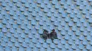 Dua orang penonton sedang menahan panas sambil menantikan laga Persib Bandung melawan PS TNI pada lanjutan Liga 1 2017 di Stadion Si Jalak Harupat, Sabtu (05/8/2017). Persib menang 3-1. (Bola.com/Nicklas Hanoatubun)