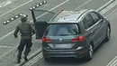 Seorang pria berlari menuju mobil sambil membawa senjata di jalanan Halle an der Saale, Halle, Jerman, Rabu (9/10/2019). Gagal menembus penjagaan sinagoge, pelakuk bergeser dan menyerang toko kebab. (Andreas Splett/ATV-Studio Halle/AFP)