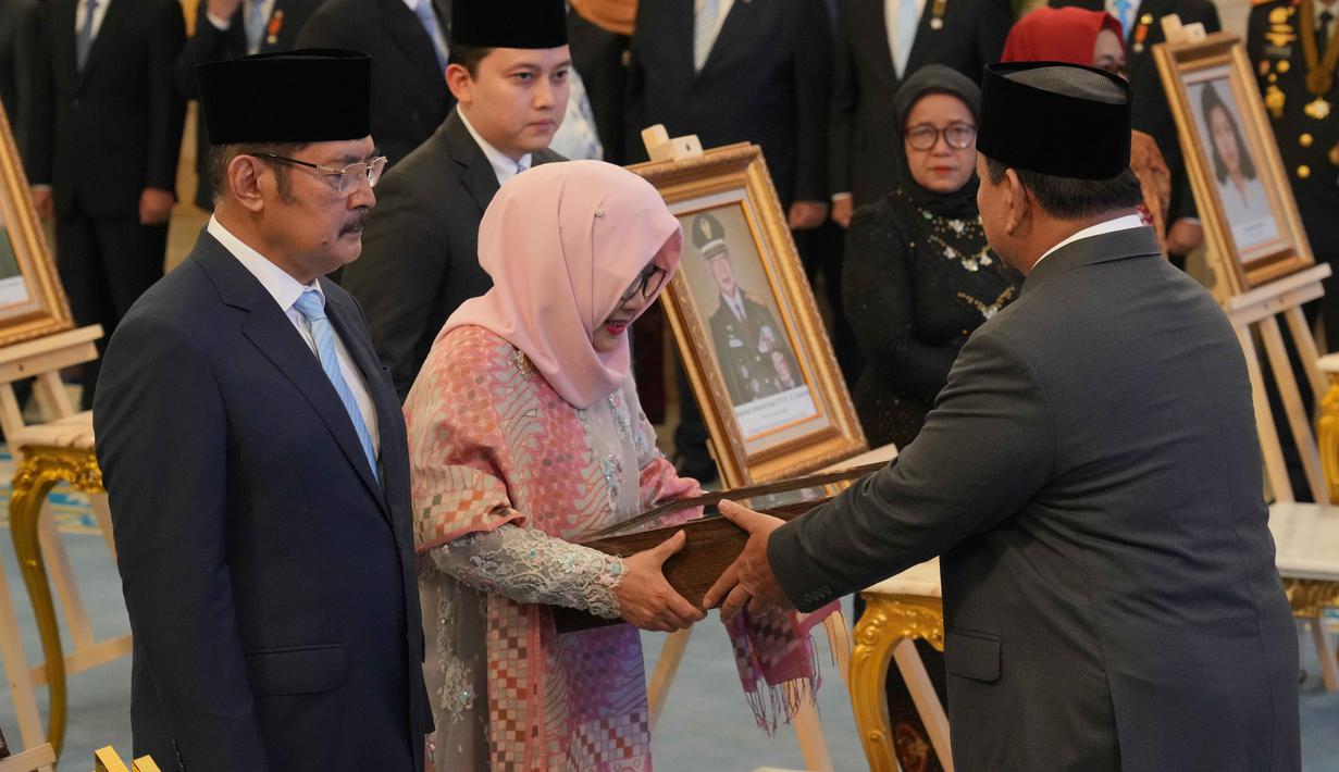 Ia diberikan gelar lantaran perjuangannya menonjol sejak masa kemerdekaan. Tampak dalam foto, Presiden Indonesia Prabowo Subianto (kanan) menyerahkan sertifikat gelar pahlawan nasional kepada putra dan putri mendiang Presiden Suharto, Siti Hardiyanti Rukmana (kedua dari kiri) dan Bambang Trihatmojo, dalam upacara pemberian gelar pahlawan nasional kepada sepuluh tokoh di Istana Negara di Jakarta, Senin 10 November 2025. (AP Photo/Achmad Ibrahim)