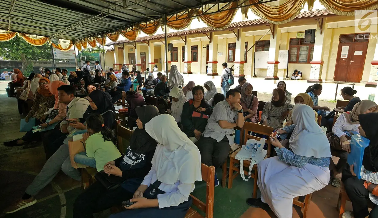 Siswa dan orangtua murid menunggu saat mengikuti seleksi Penerimaan Peserta Didik Baru (PPDB) di SMAN 1 Depok, Kota Depok, Jawa Barat, Selasa (18/6/2019). PPDB SMA dibagi menjadi tiga jalur yakni zonasi, prestasi, dan pemindahan orangtua. (Liputan6.com/Herman Zakharia)