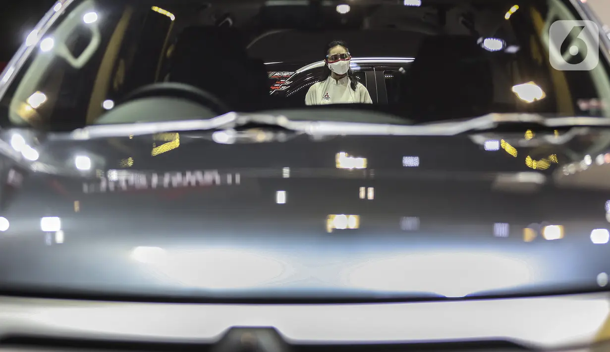 Sales Promotion Girl berdiri dekat mobil yang dipamerkan di Indonesia International Motor Show (IIMS) Hybrid 2021, JiExpo Kemayoran, Jakarta, Kamis (16/4/2021). Pameran otomotif IIMS Hybrid 2021 berlangsung pada 15-25 April. (Liputan6.com/Johan Tallo)