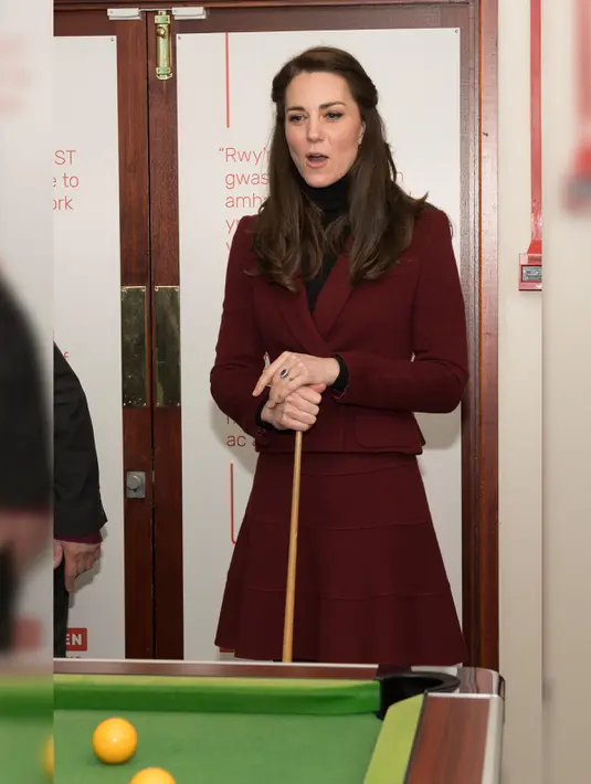 Ekspresi Kate Middleton saat bermain biliar dalam kunjungannya ke MIST, sebuah proyek kesehatan mental bagi anak dan remaja di Pontypool, Wales, Inggris, Inggris (22/2). (AFP Photo / Pool / Paul Edwards)