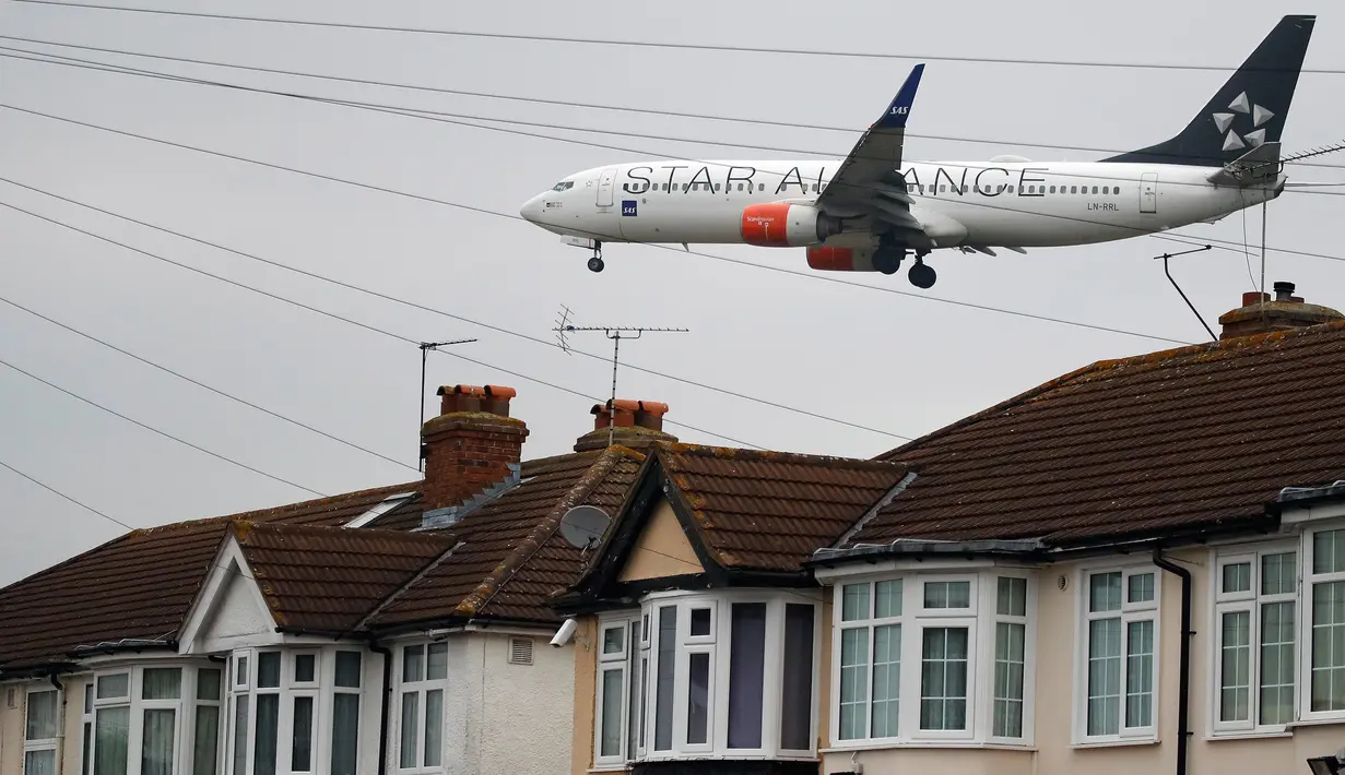 Pesawat Scandinavian Airlines terbang rendah dekat atap rumah saat akan mendarat di Bandara Heathrow, London, 25 Oktober 2016. Perumahan yang terletak di Myrtle Avenue itu hanya sekitar 91 meter dari landasan Bandara Heathrow. (AP Photo / Frank Augstein)