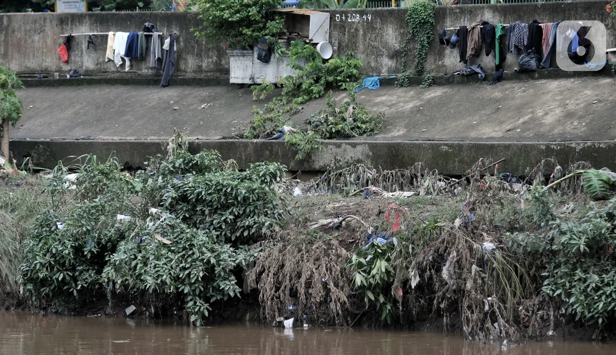 Jemuran baju milik warga yang basah akibat banjir terlihat di pinggir Kanal Banjir Barat (KBB), Jakarta, Rabu (8/1/2020). (merdeka.com/Iqbal S Nugroho)