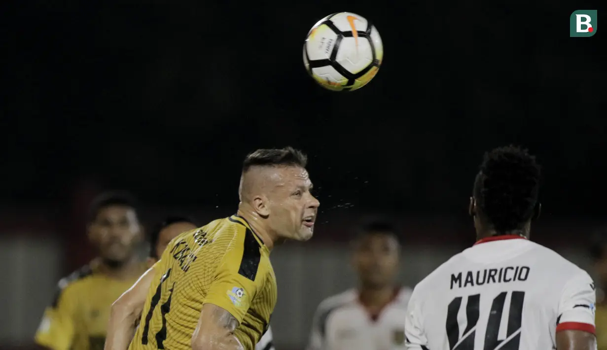 Striker Bhayangkara FC, Nikola Komazec, duel udara dengan bek Mitra Kukar, Mauricio Leal, pada laga Liga 1 di Stadion PTIK, Jakarta, Kamis (17/5/2018). Bhayangkara FC menang 1-0 atas Mitra Kukar. (Bola.com/M Iqbal Ichsan)